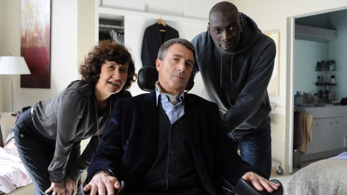 Anne Le Ny, François Cluzet e Omar Sy in una scena del film Quasi amici - Intouchables